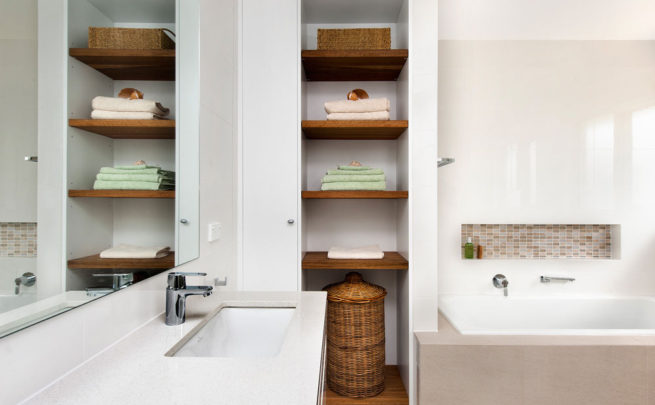 Bathroom with timber shelving and an inset shelf over the bathtub