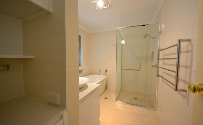 Bathroom with neutral tones and glass shower recess